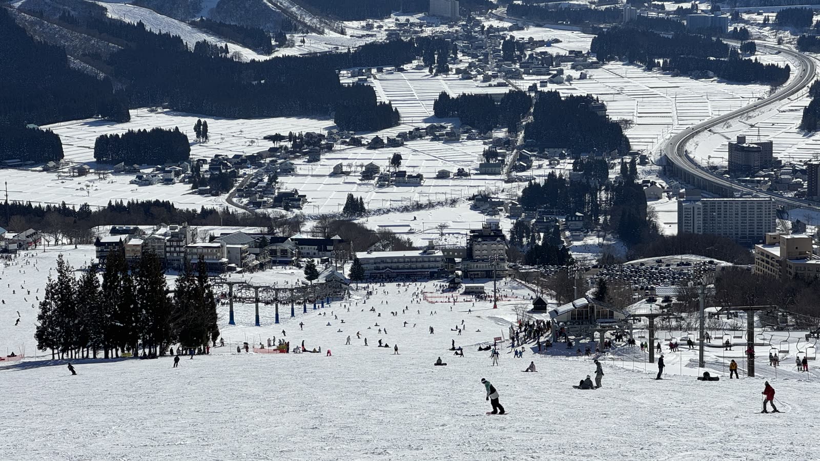 從岩原滑雪場高處俯瞰整片雪道,遠方是湯澤市街與群山